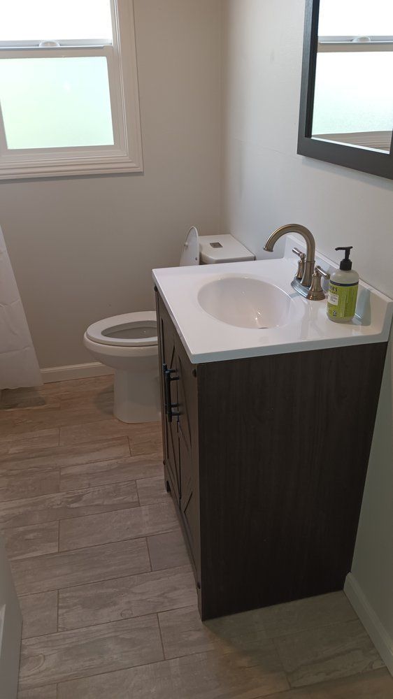 A bathroom with a sink , toilet and mirror.