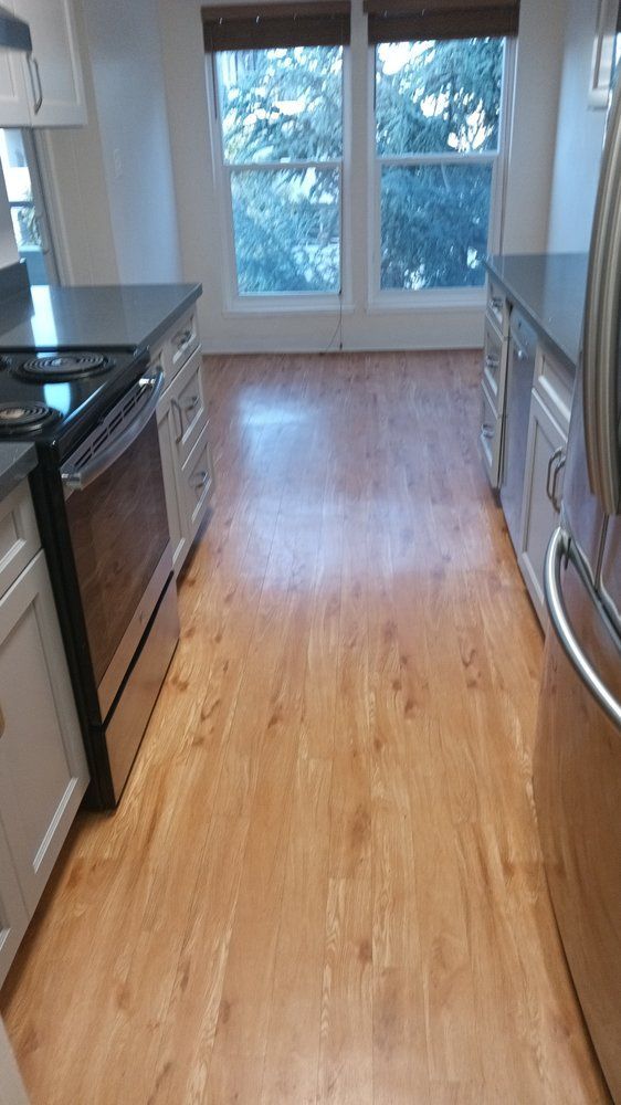 A kitchen with hardwood floors and stainless steel appliances.