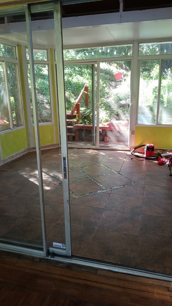 A room with a lot of windows and sliding glass doors.