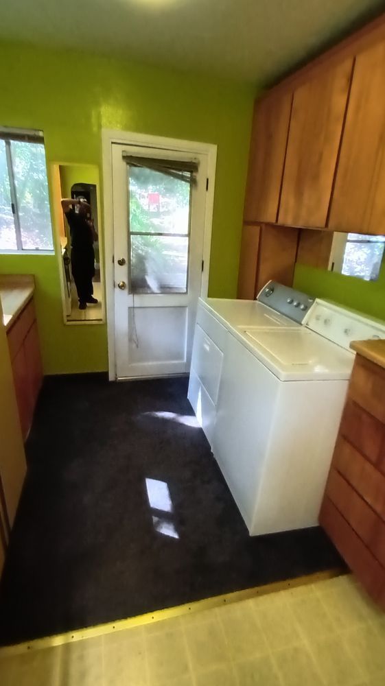 A laundry room with a washer and dryer and a mirror.