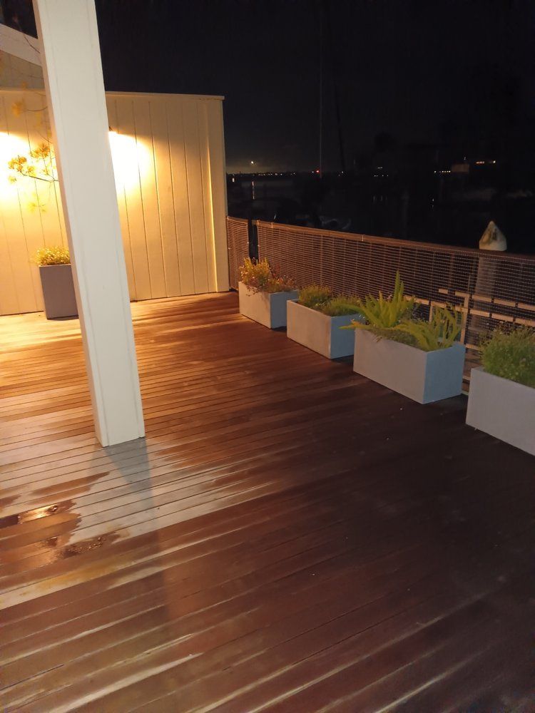 A wooden deck with planters on it at night