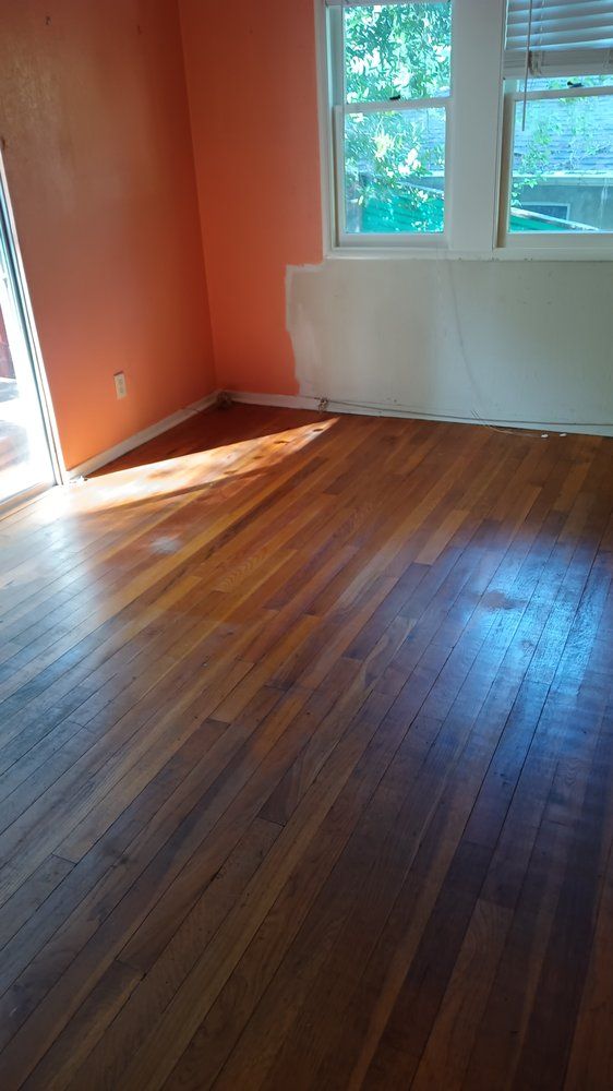 An empty room with hardwood floors and a window.