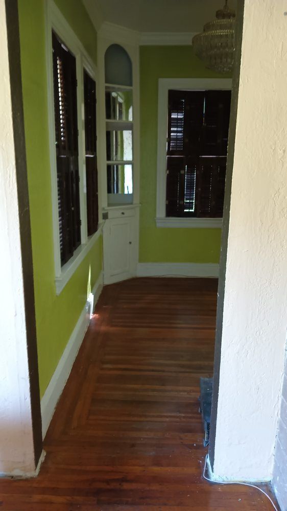 A hallway with wooden floors and green walls