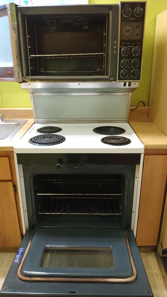 A stove with the door open in a kitchen.