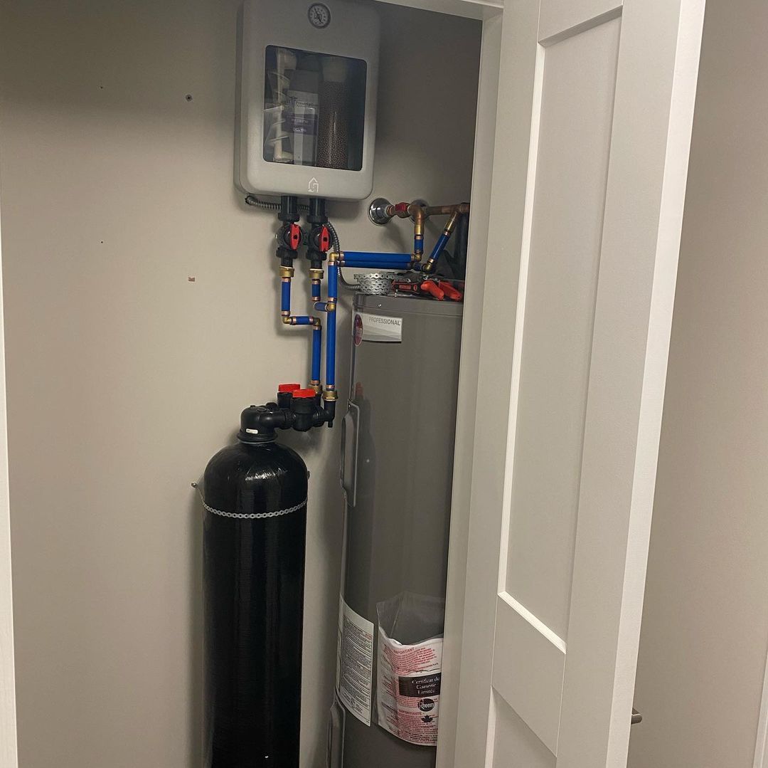 A water heater is sitting in a closet next to a door.