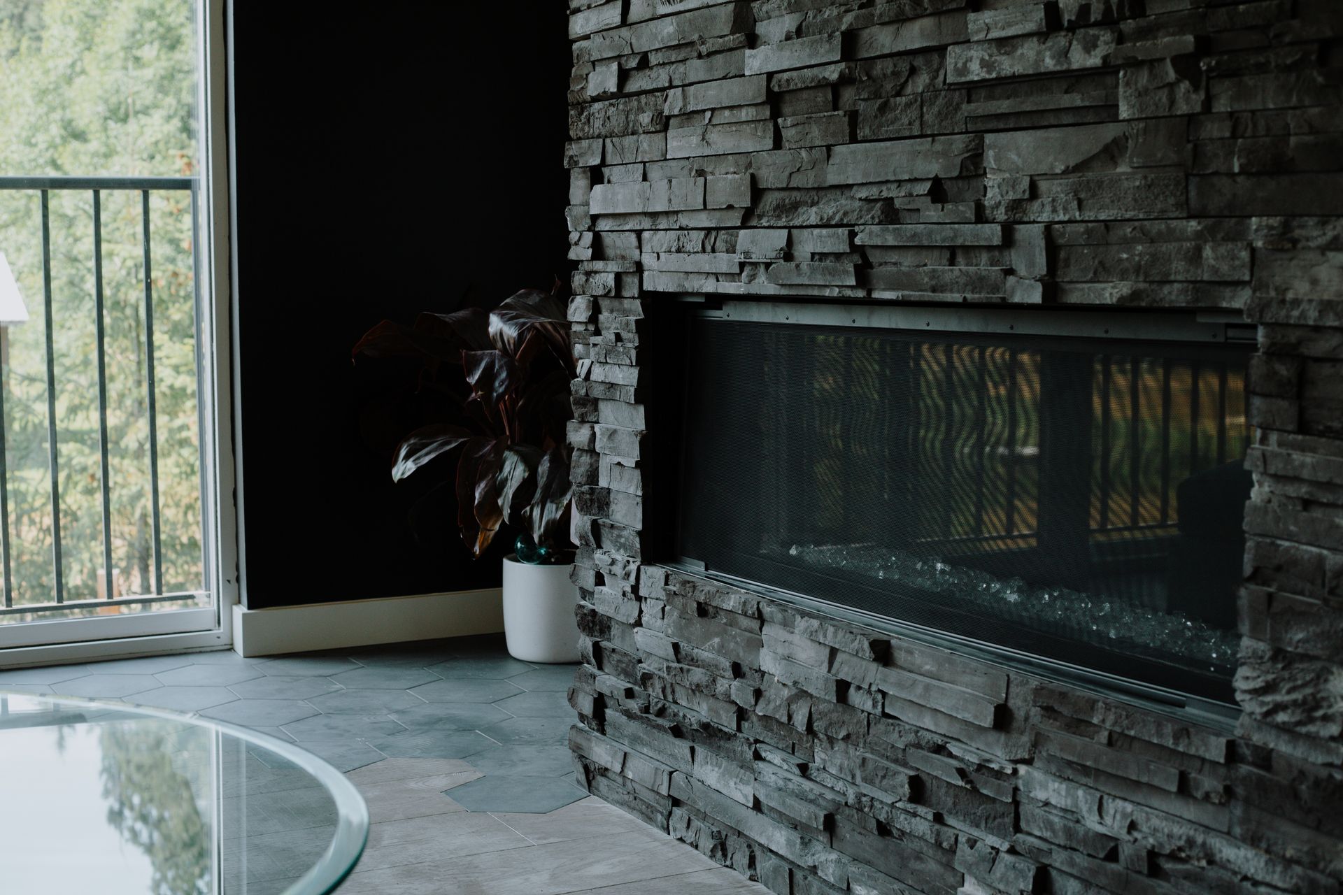 A living room with a fireplace and a glass table.