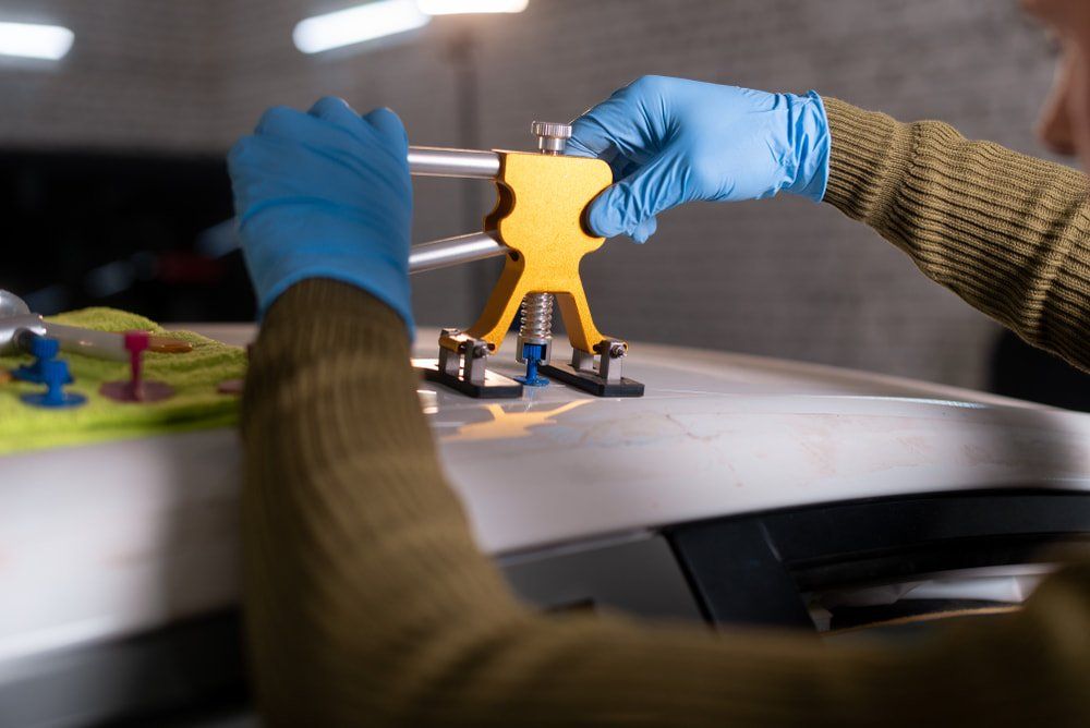 The Process Of Removing Dents From The Roof Of The Car — Spray Painter in Park Avenue, QLD