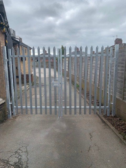 A metal gate is sitting on the side of a road.