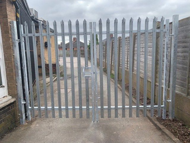 A metal fence is sitting on the side of a road.