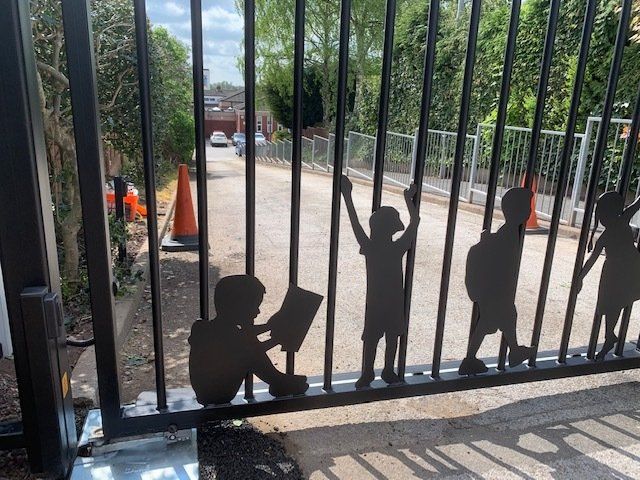 A gate with silhouettes of children on it