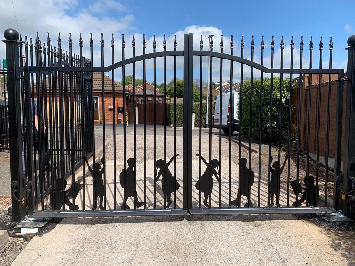 A black gate with silhouettes of children on it