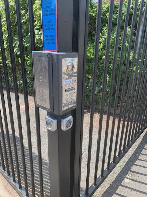 A close up of a gate with a button on it.