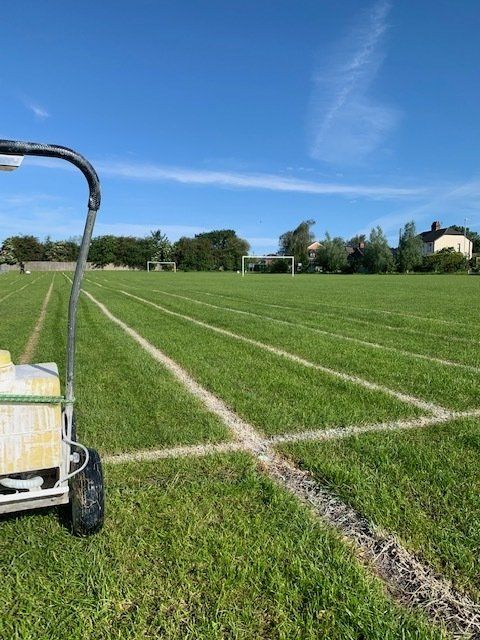 A cart is sitting in the middle of a soccer field.