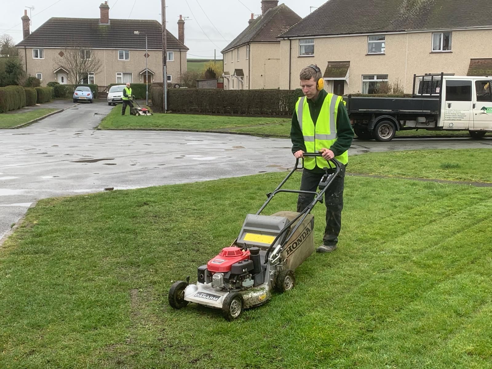 A man is using a lawn mower to cut the grass.