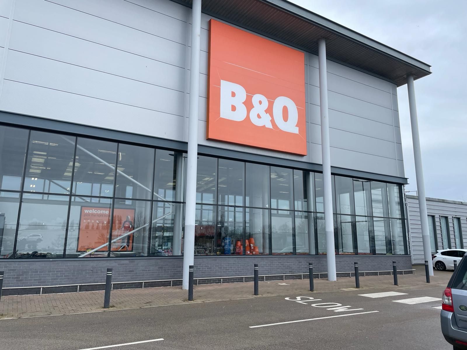 A car is parked in front of a b & q store