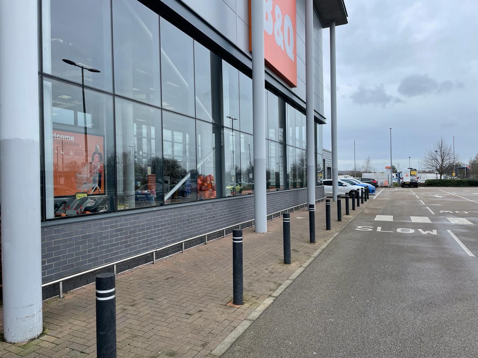 A large building with a lot of windows and a parking lot in front of it