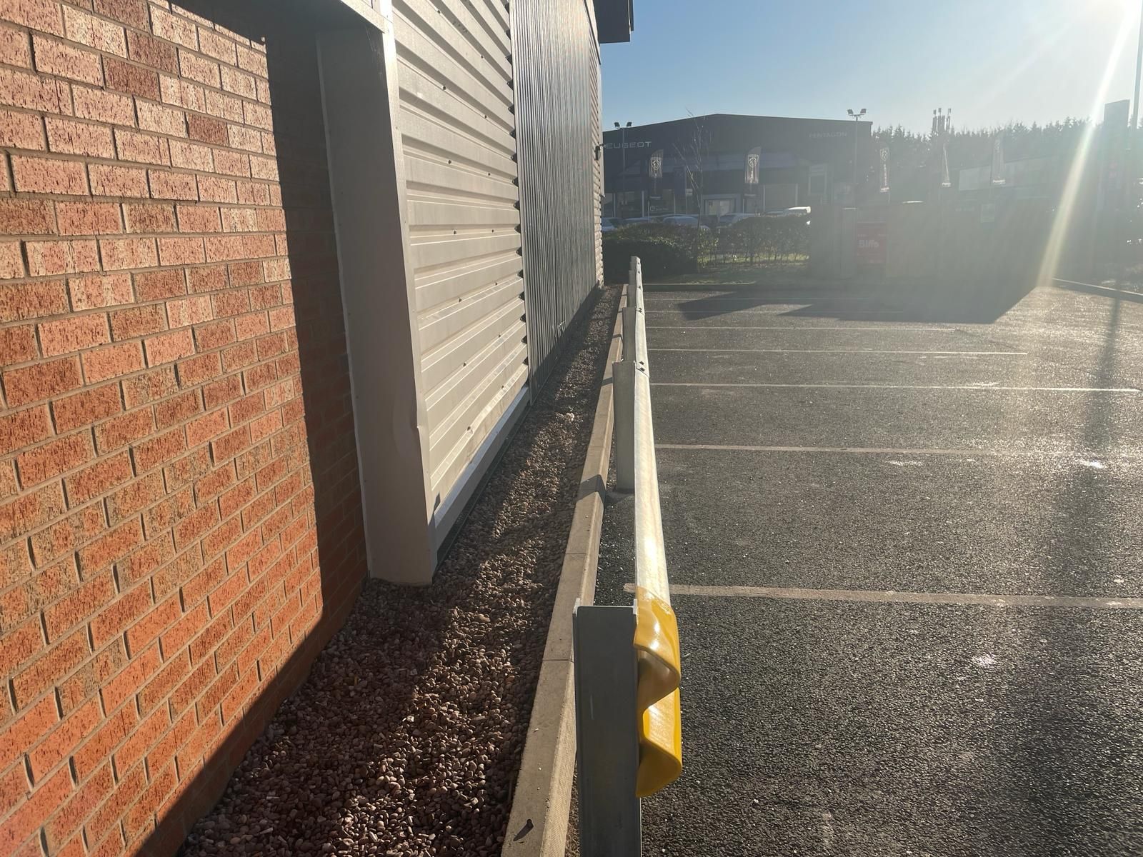 A brick building with a parking lot in front of it.