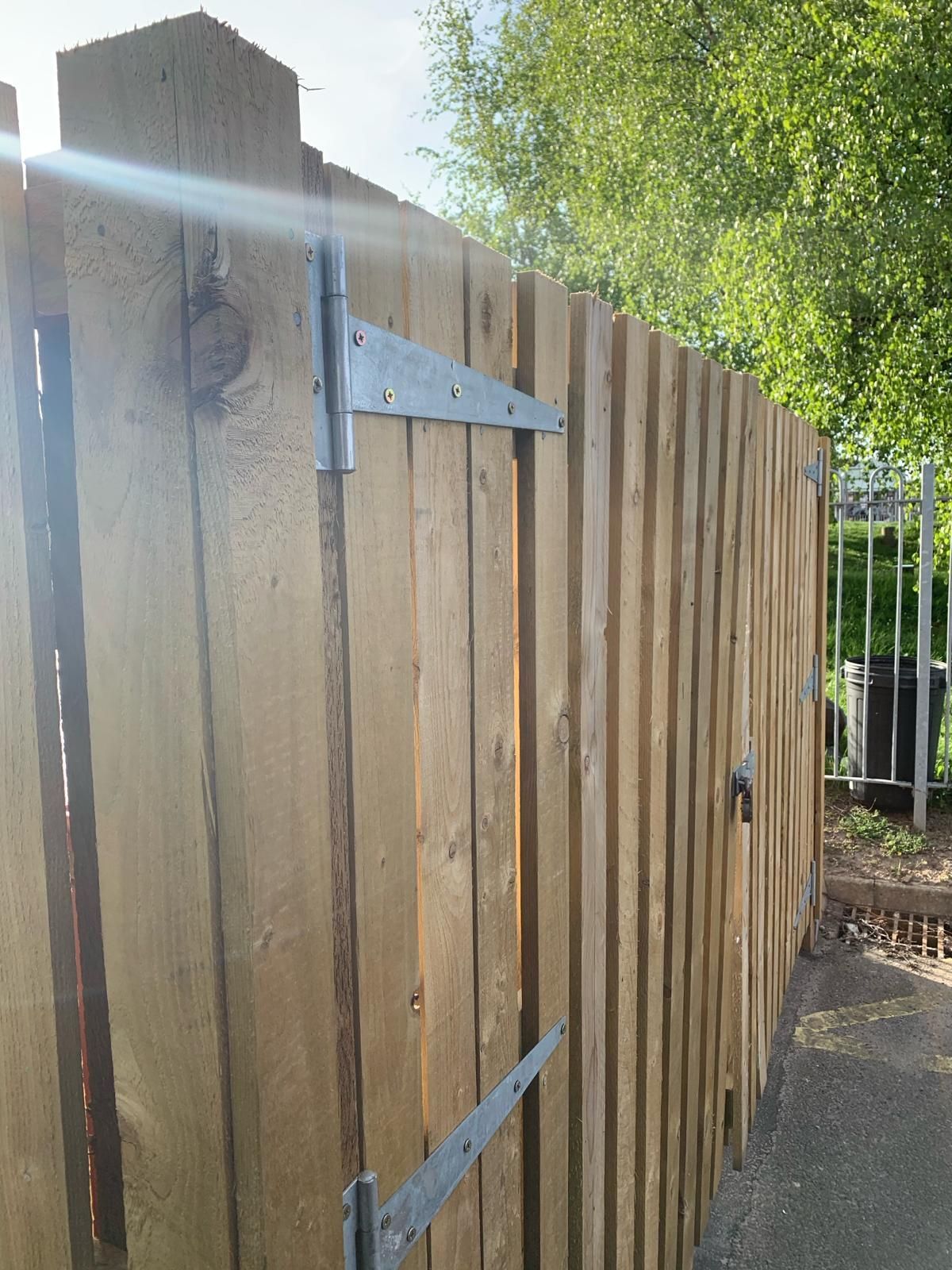 A wooden fence with a metal hinge on it