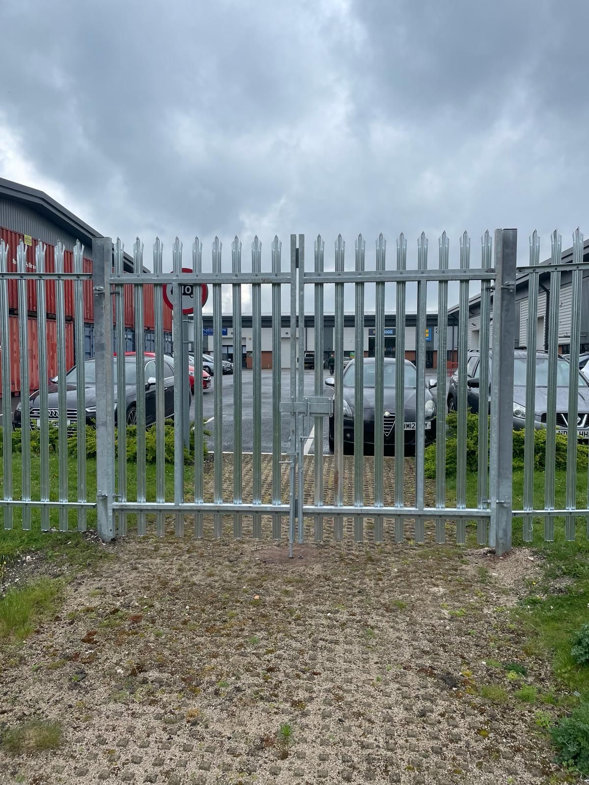 A metal fence with a gate in front of a building.