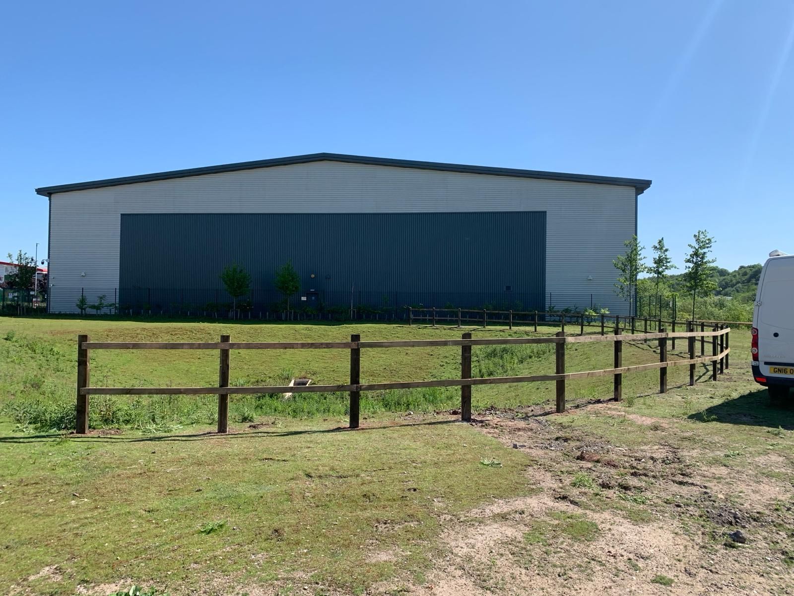 A large building with a wooden fence in front of it
