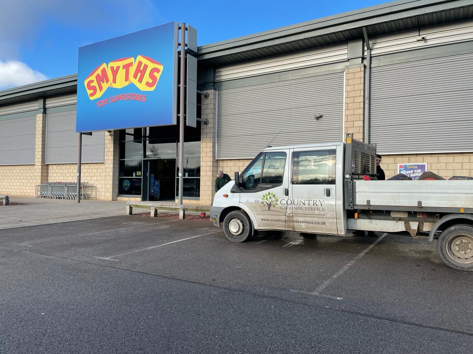 A white truck is parked in front of a toy store.