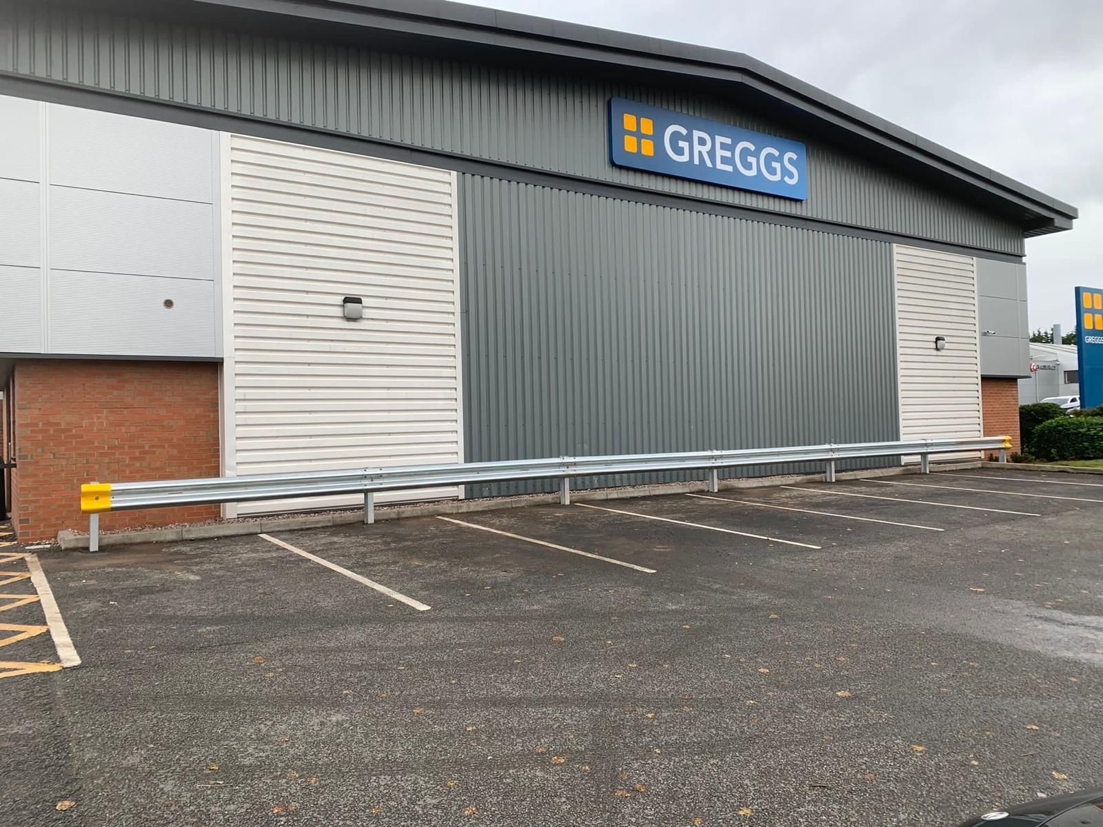 A large building with a sign that says greggs on it