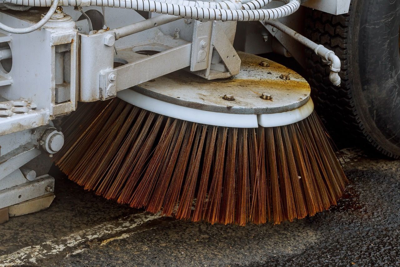 A close up of a brush on a street sweeper