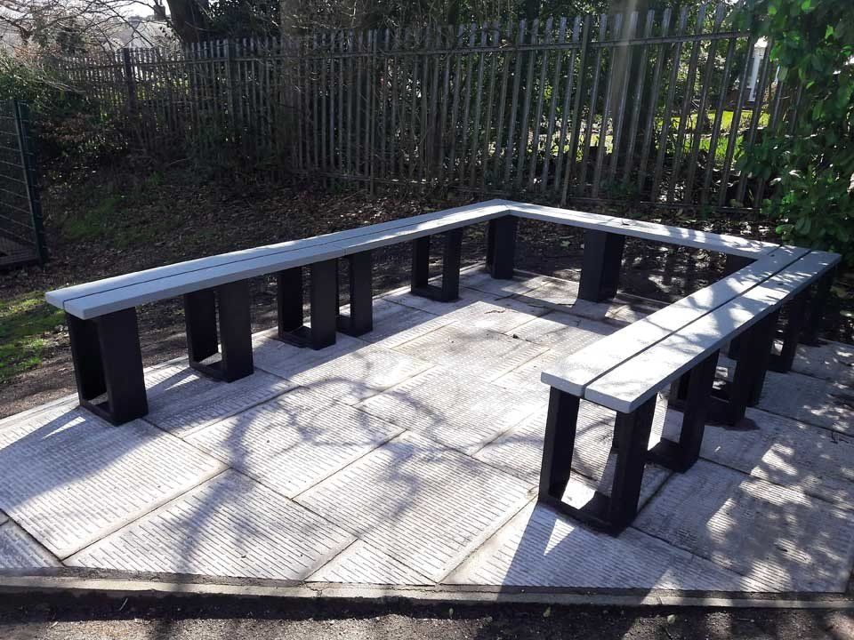 A row of benches are lined up in a circle on a patio.