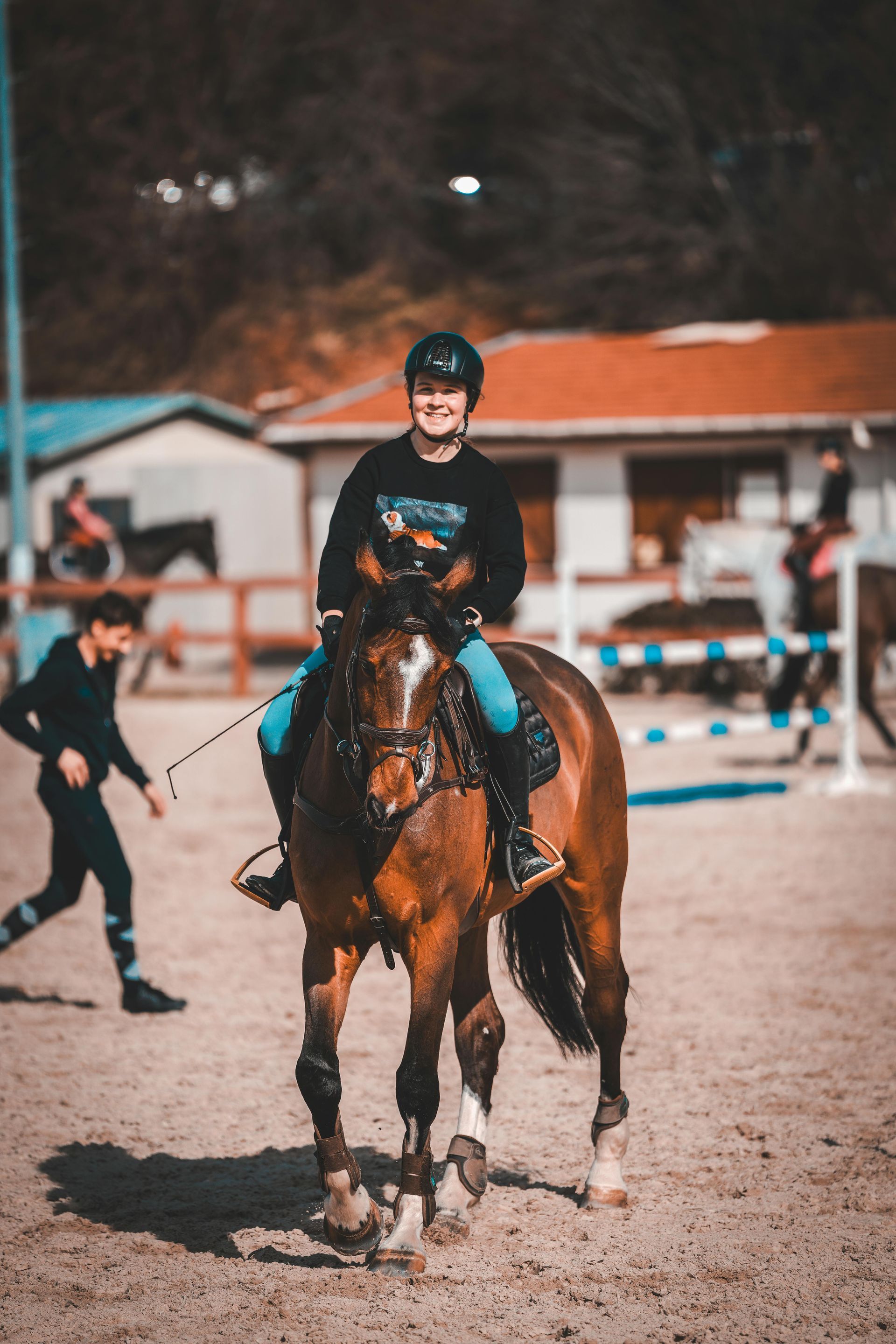 A man is riding a brown horse in a dirt field.
