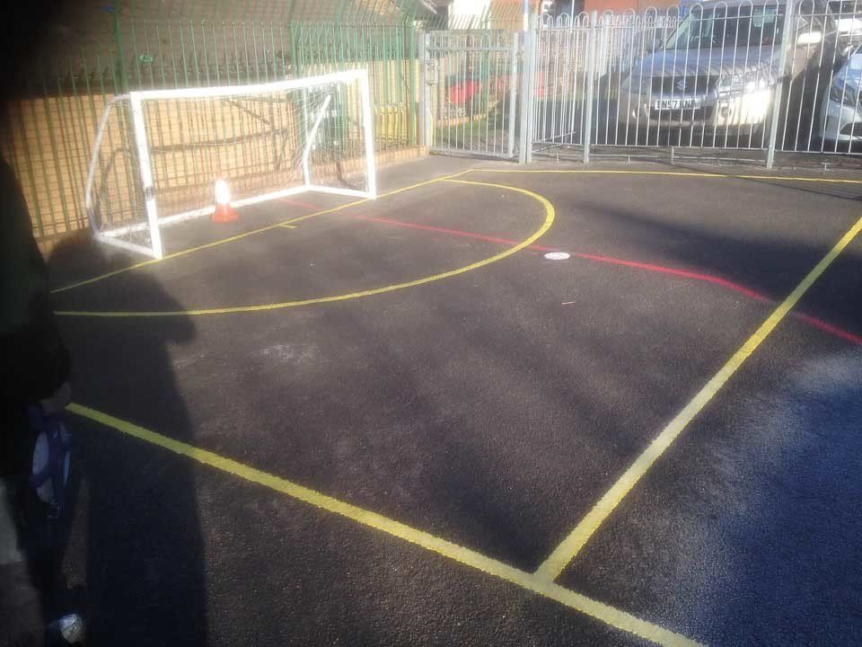 A soccer field with a goal and yellow lines