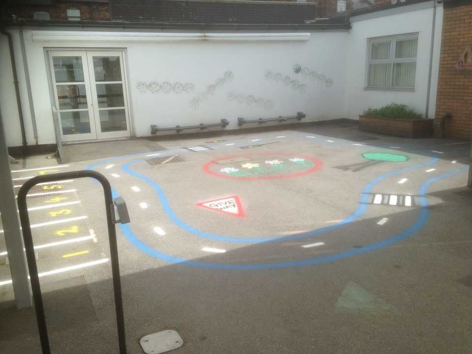 A concrete courtyard with a drawing of a road on it