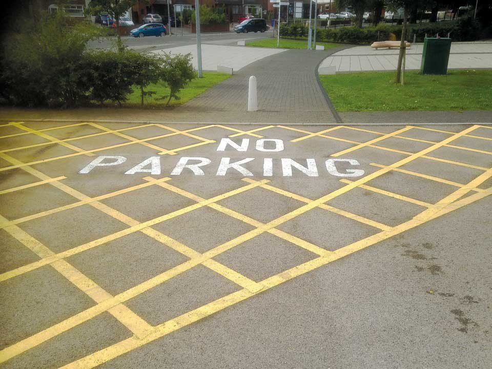A no parking sign is painted on the road