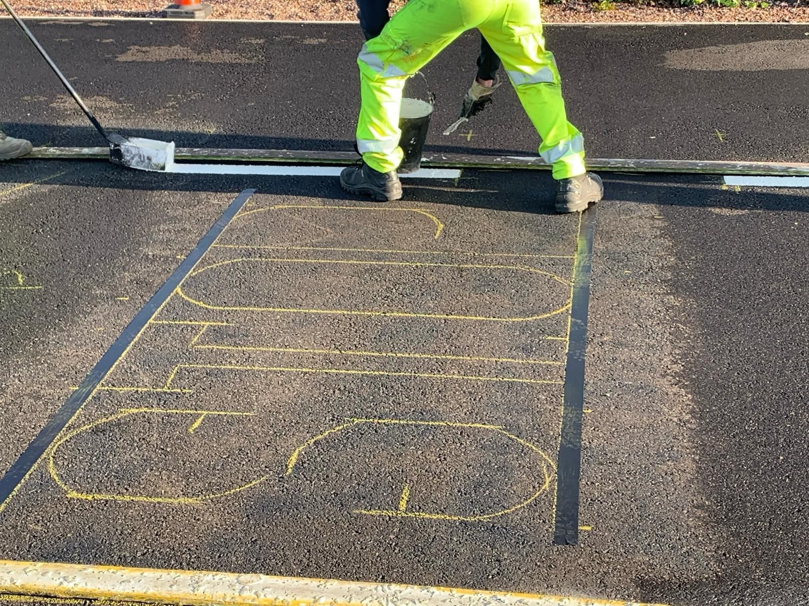 A man in yellow pants is standing on a concrete surface.