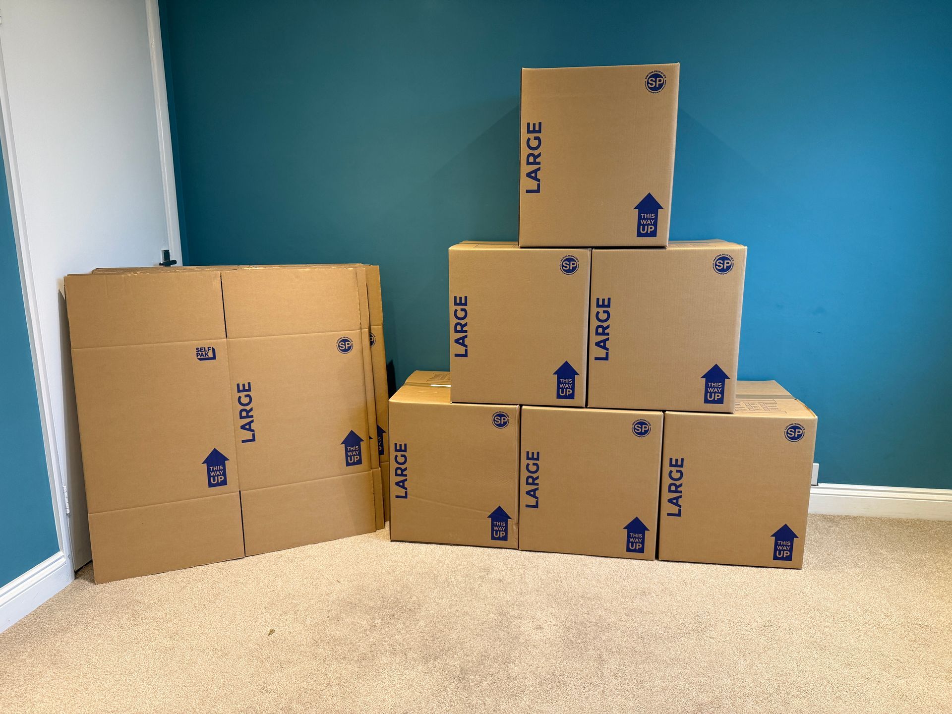 A stack of large removal boxes next to some that are still flat packed