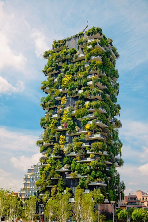 Un alto edificio ricoperto di tante piante verdi e alberi.