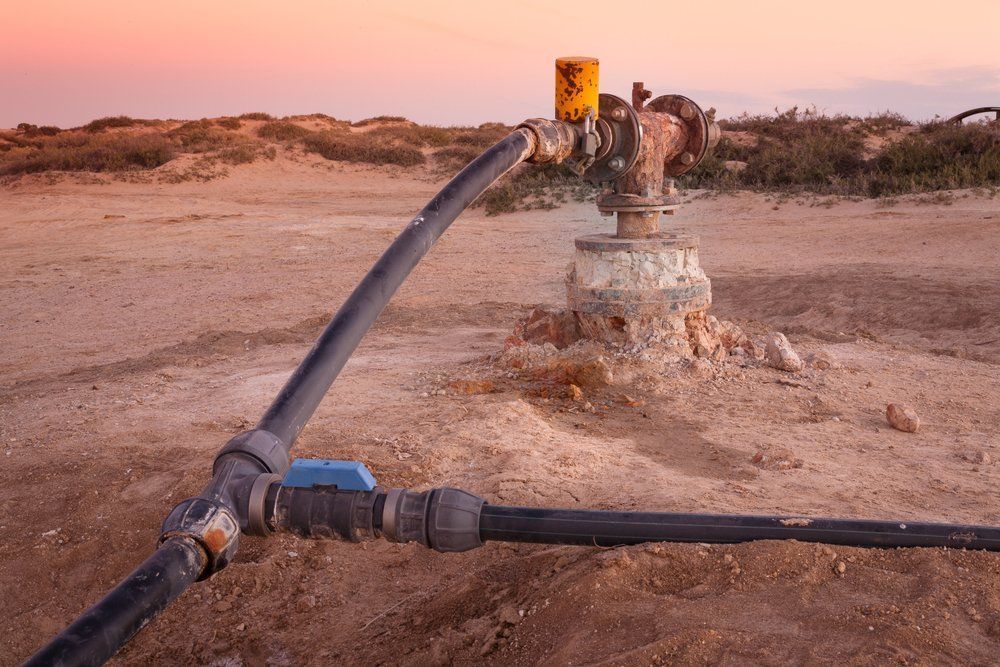 Well Head and Piping in a Desert Setting During Sunset — Wilson's Drilling in Childers, QLD