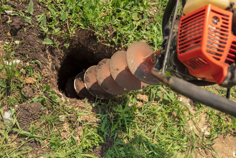 Gas-powered Auger Drilling a Hole in the Dirt and Grass — Wilson's Drilling in Moore Park Beach, QLD
