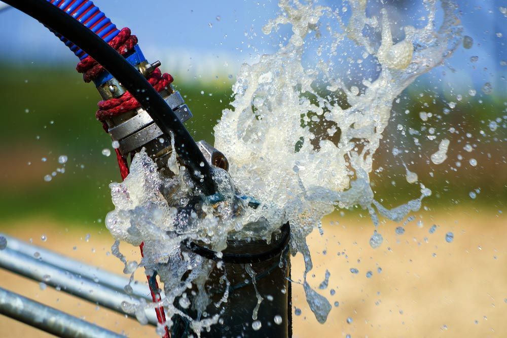 Water Gushing From a Black Pipe Connected to a Hose — Wilson's Drilling in South Kolan, QLD