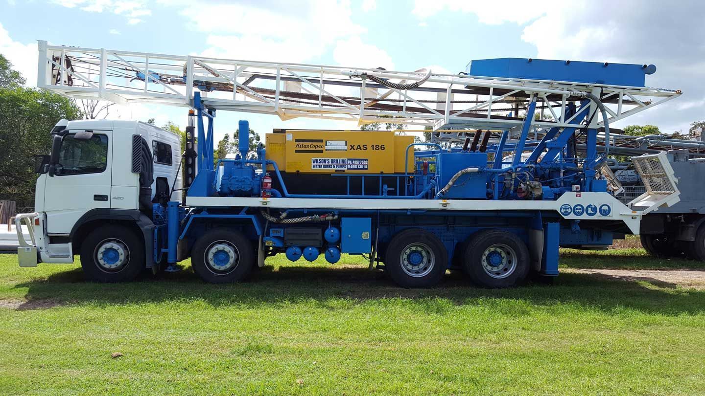 White and Blue Drilling Rig Truck Parked on Grass — Wilson's Drilling in South Kolan, QLD