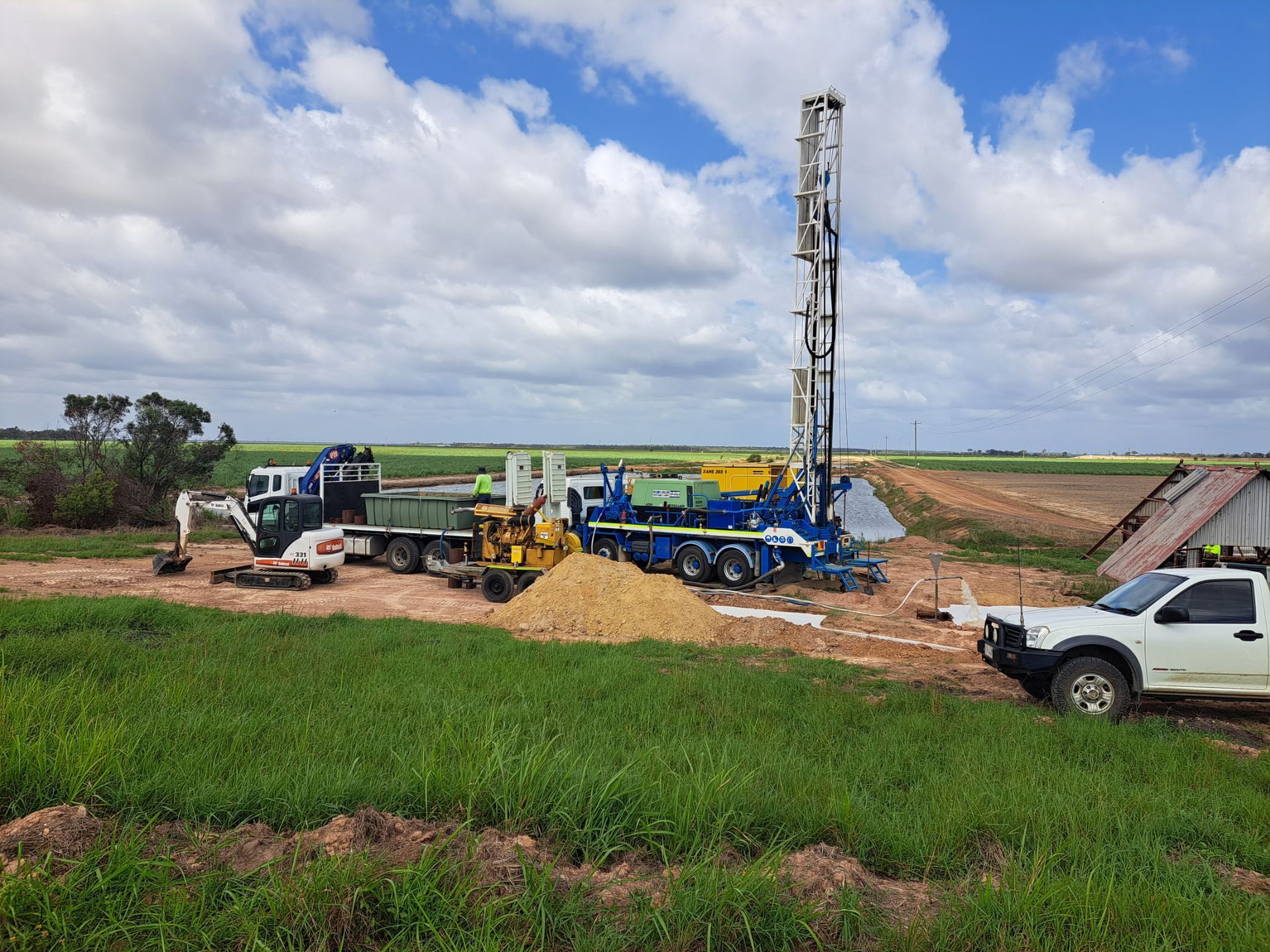 Drilling Rig in A Field, with Support Vehicles — Wilson's Drilling in South Kolan, QLD
