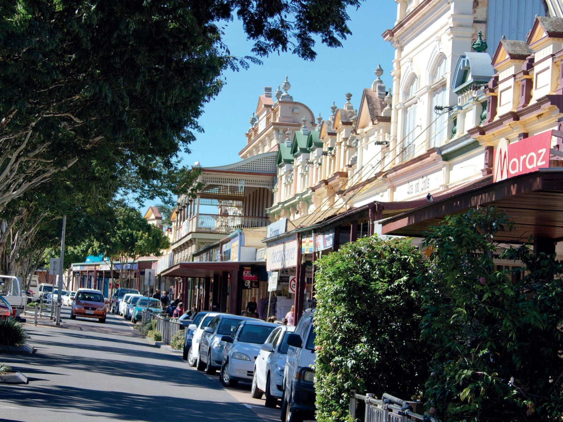 Street Lined With Shops and Parked Cars Under a Sunny Sky — Wilson's Drilling in Childers, QLD
