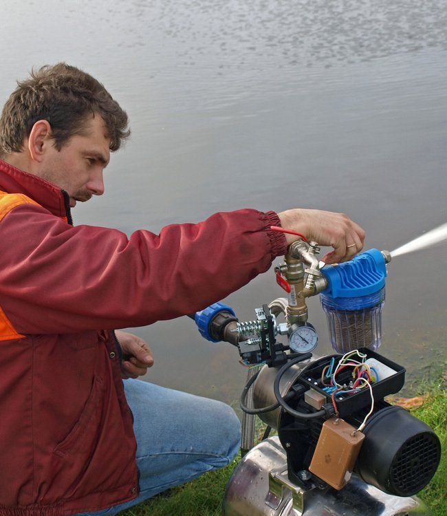 Man Operating Water Pump Near a Lake, Inspecting the Water Flow — Wilson's Drilling in South Kolan, QLD