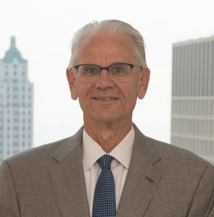 A man in a suit and tie is smiling for the camera