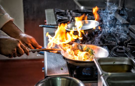 chef cooking on pan in asian restaurant
