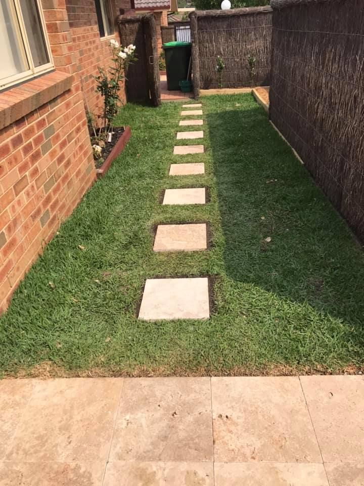 A Brick Building with a Lush Green Lawn and a Stone Walkway Leading to it | Central Coast, NSW | Budget Lawns Plus