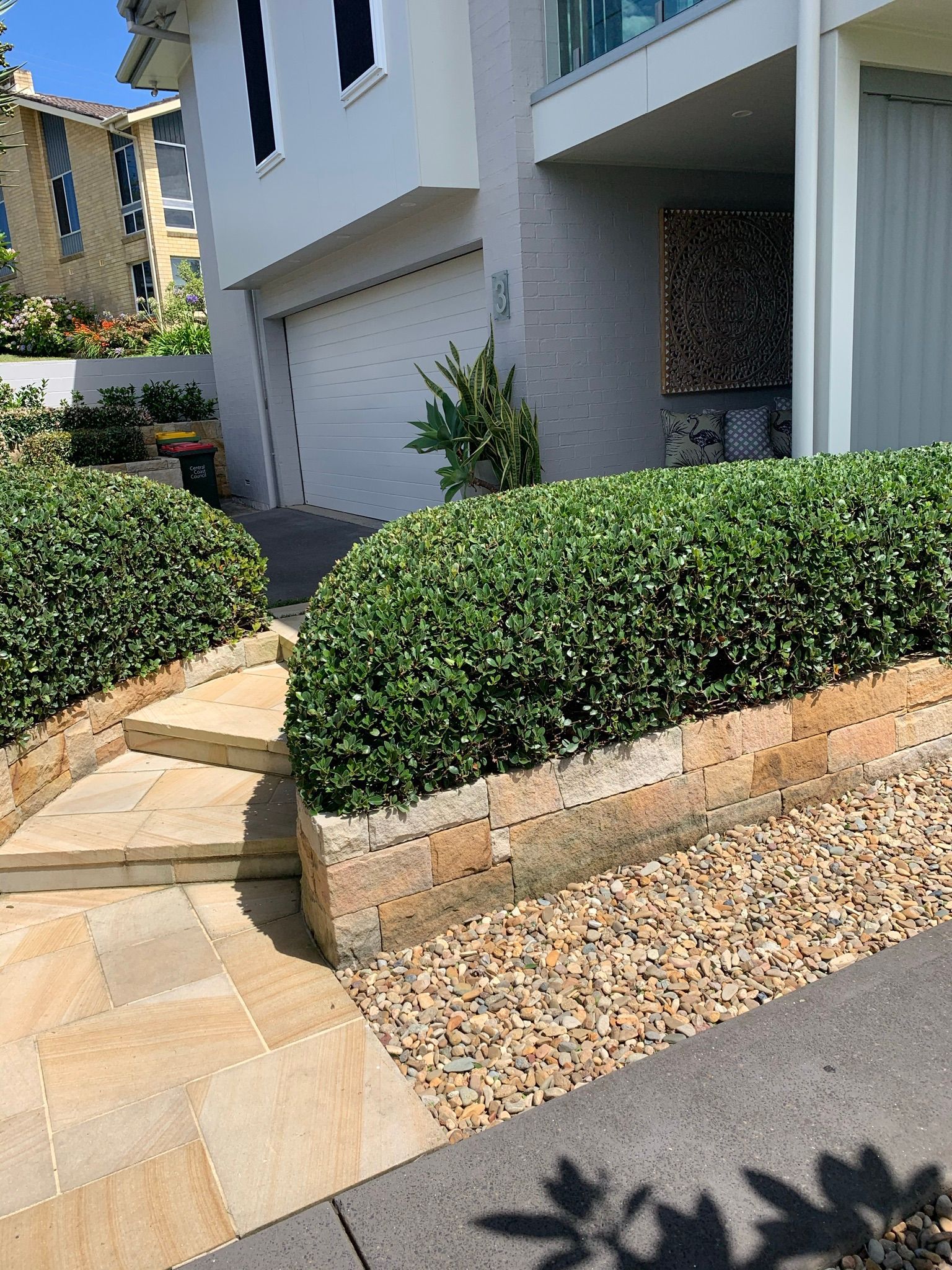 There is a Shadow of a Tree on the Sidewalk in front of a House | Central Coast, NSW | Budget Lawns Plus