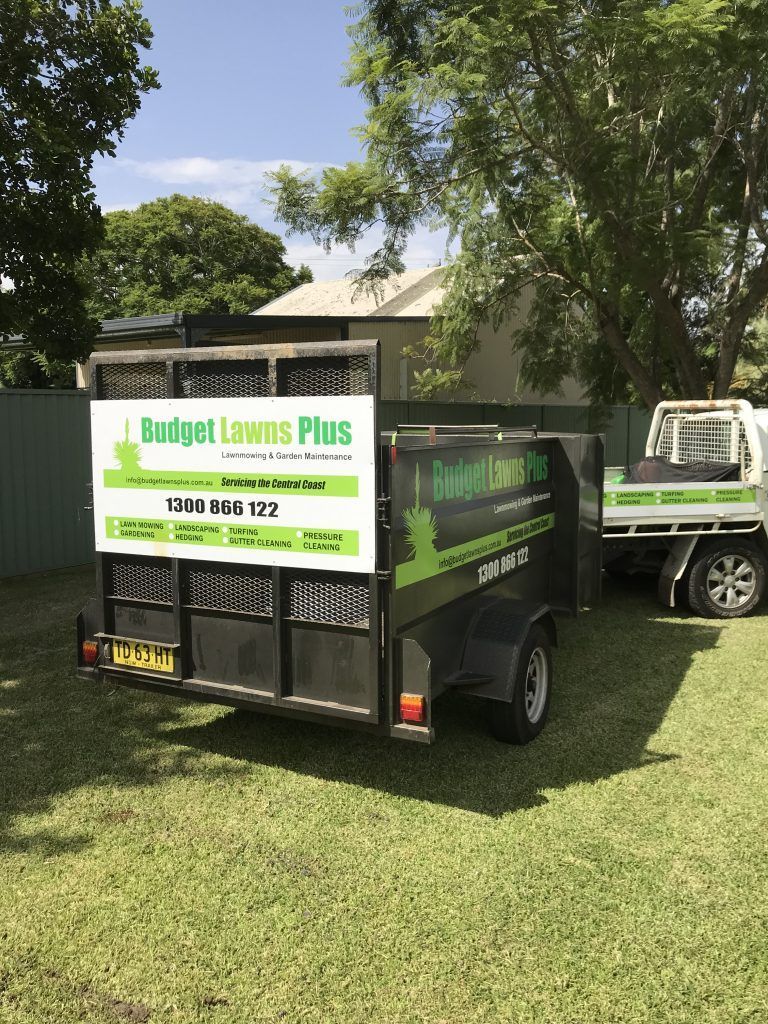 A Trailer is Parked in the Grass Next to a Truck | Central Coast, NSW | Budget Lawns Plus