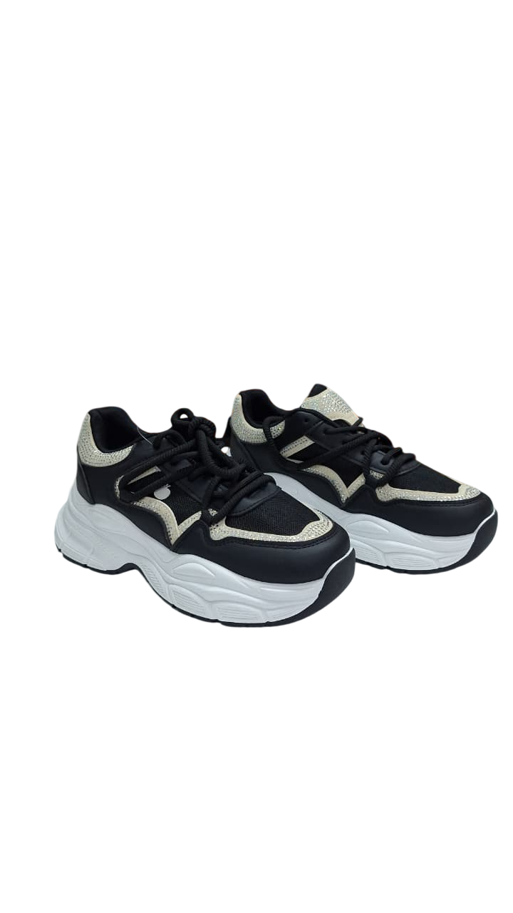 Zapatillas deportivas negras y beige con suela gruesa blanca.