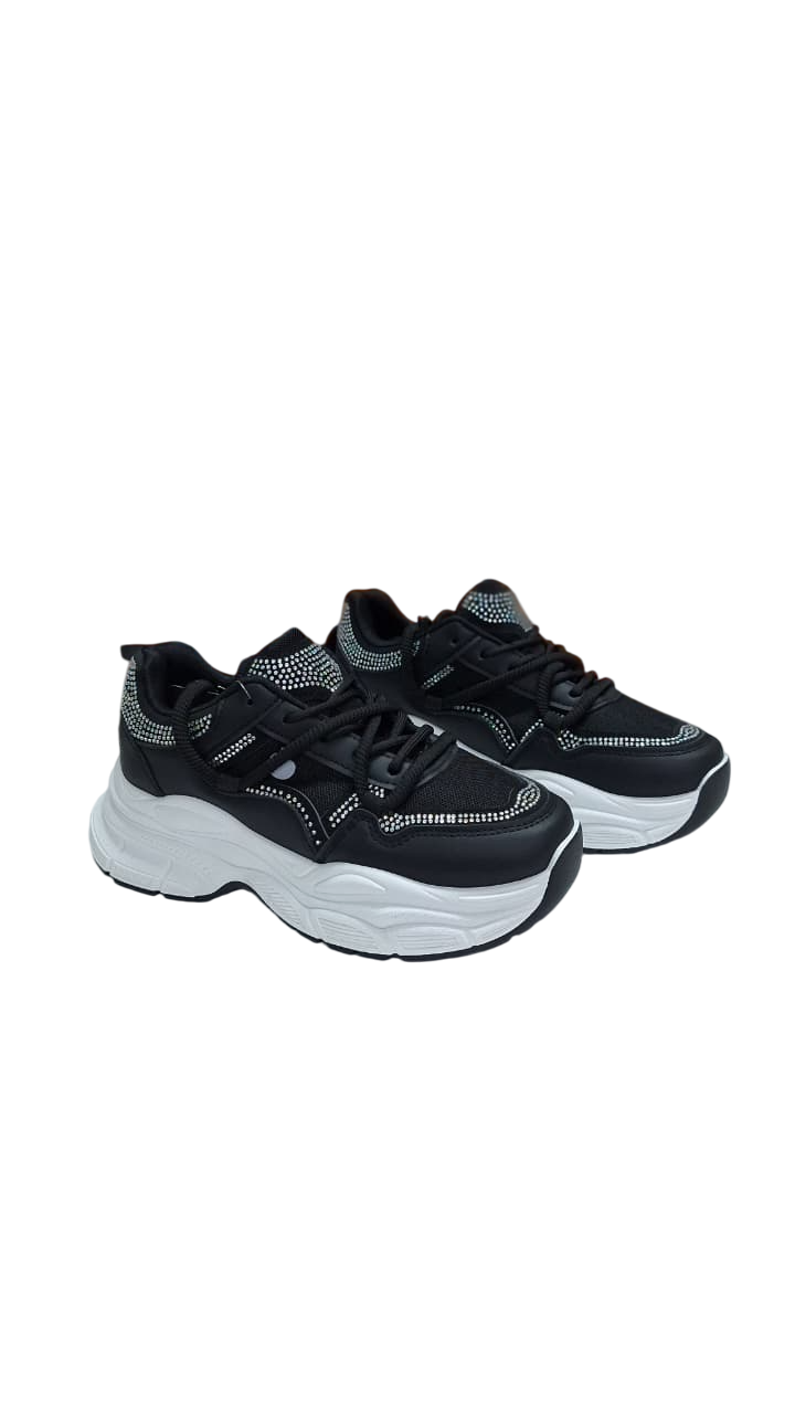 Zapatillas deportivas negras y beige con suela gruesa blanca.