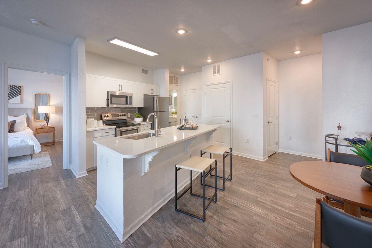 Open-concept kitchen with island and stainless-steel appliances in a modern apartment.